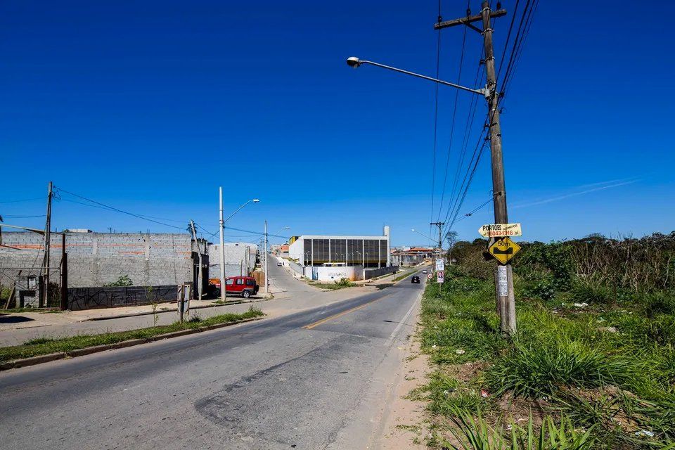 Uma estrada com muitas linhas de energia e um prédio ao fundo.