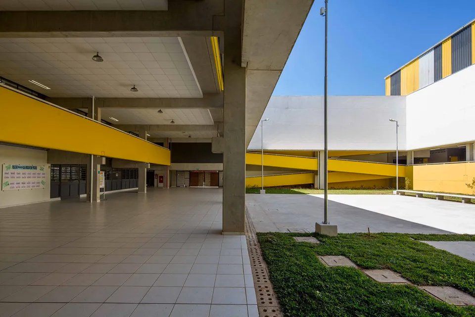 Um prédio grande com muitas janelas e muita grama na frente.