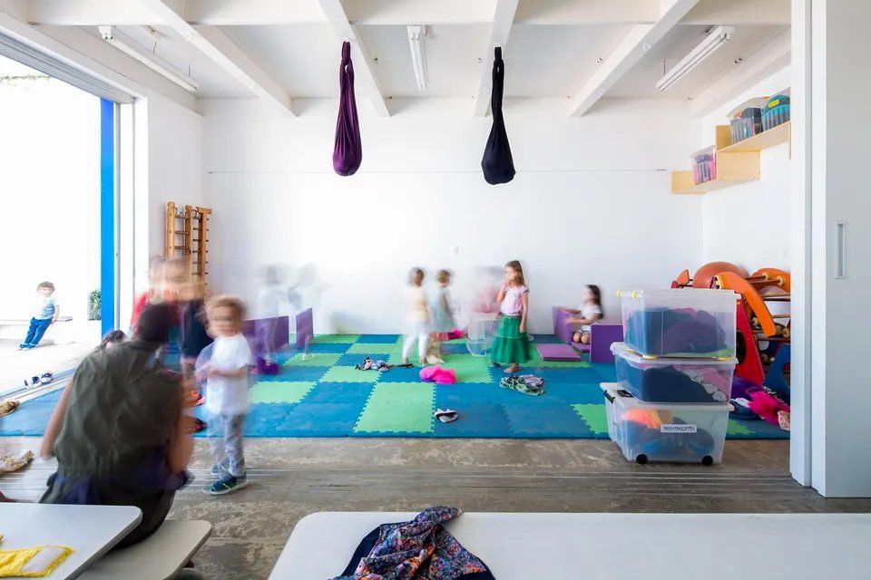 Um grupo de crianças está brincando em uma sala de jogos.