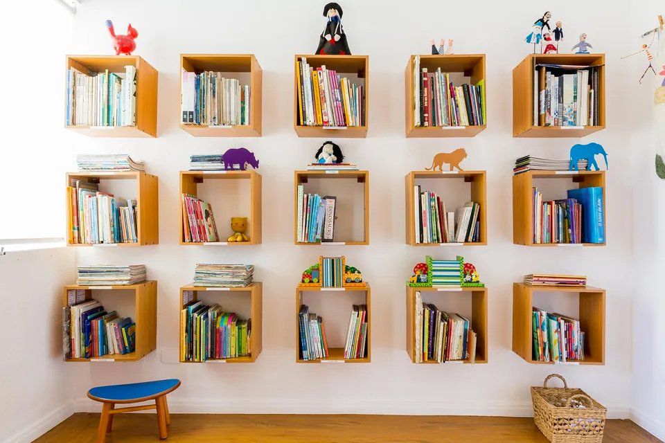 Uma parede cheia de livros e brinquedos.