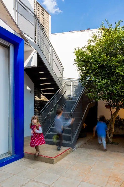 Uma garota de vestido vermelho está descendo uma escada.