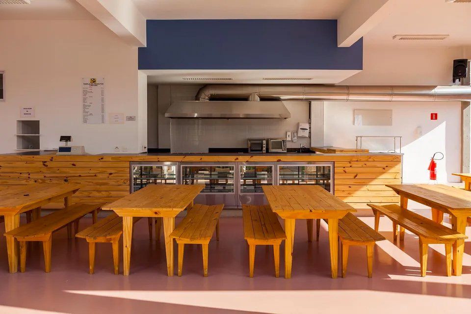 Uma cozinha com mesas e bancos de madeira