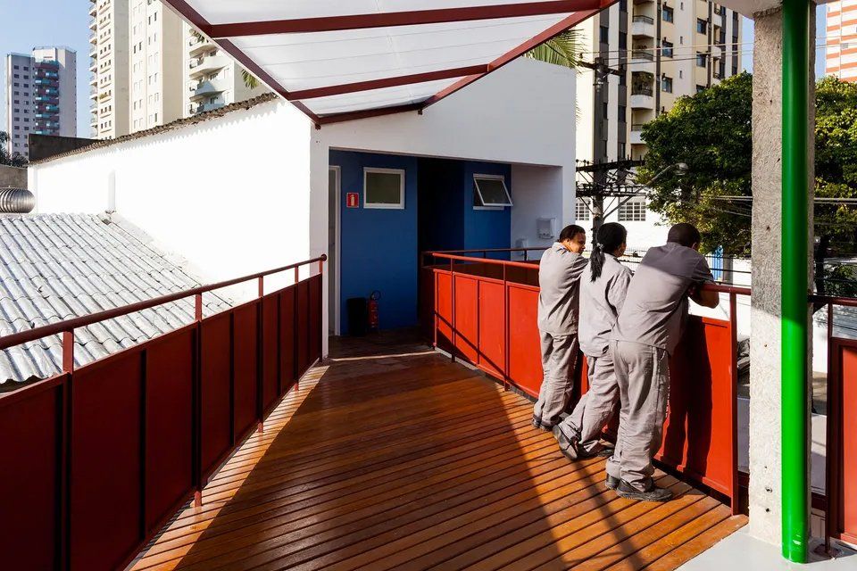 Um grupo de pessoas está em uma passarela de madeira