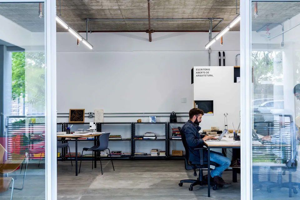 Um homem está sentado em uma mesa em um escritório.