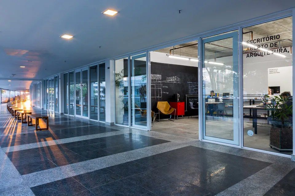 Um grande edifício com muitas janelas, mesas e cadeiras.