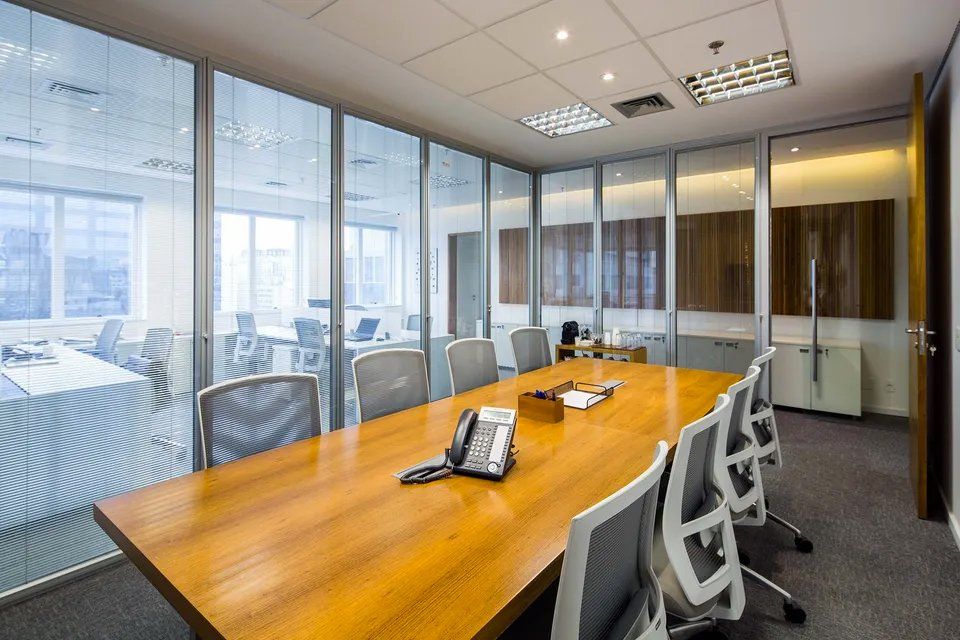 Uma sala de conferências com uma longa mesa e cadeiras de madeira.