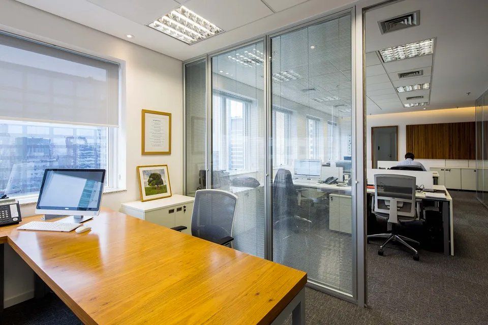 Uma mesa de madeira com um computador em um escritório.