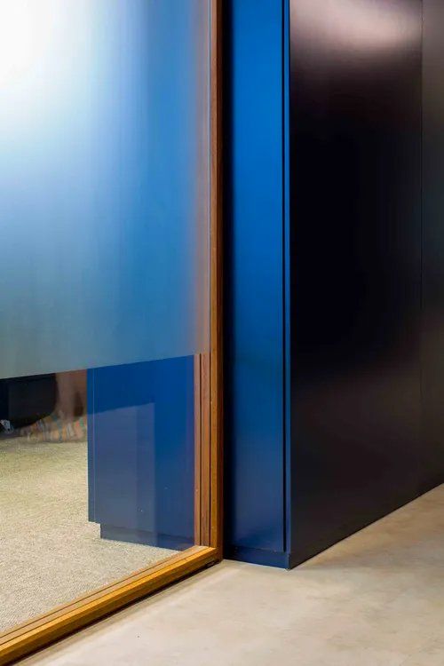 Um close de uma porta azul com uma moldura de madeira em uma sala.