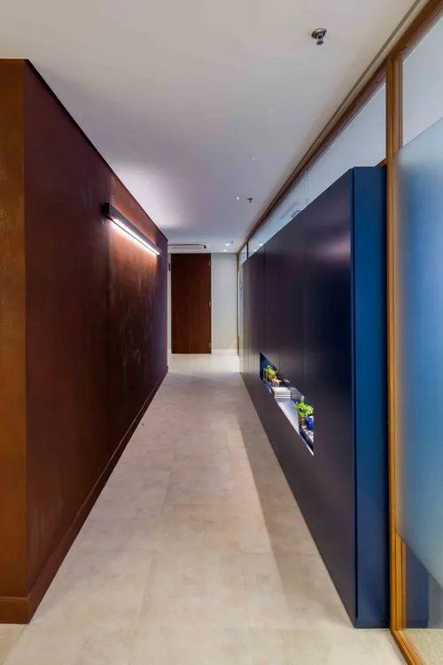 Um longo corredor com uma parede marrom e uma parede azul