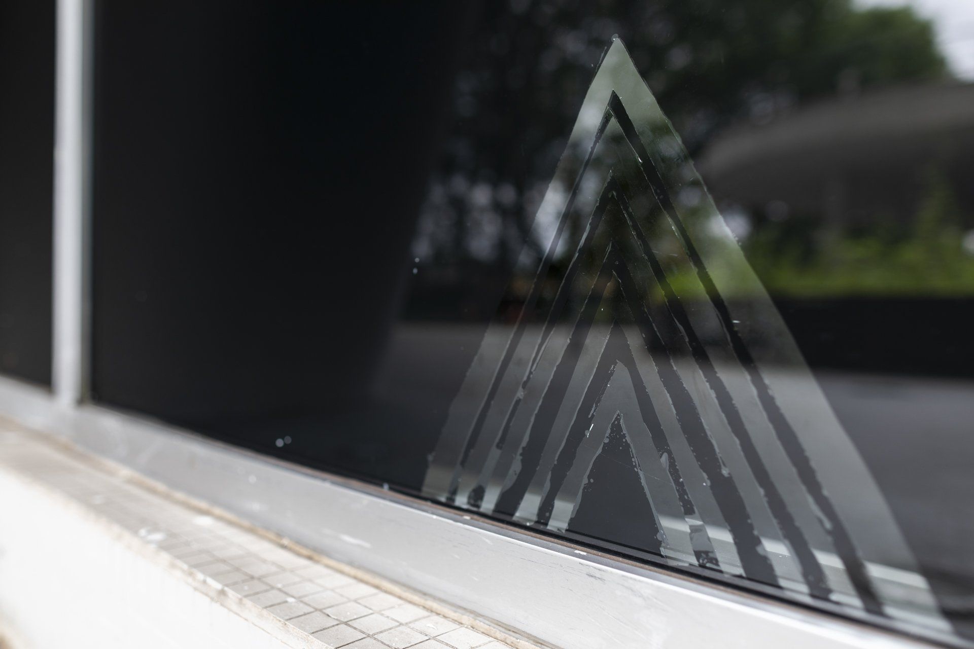 Um close de uma janela com um triângulo.