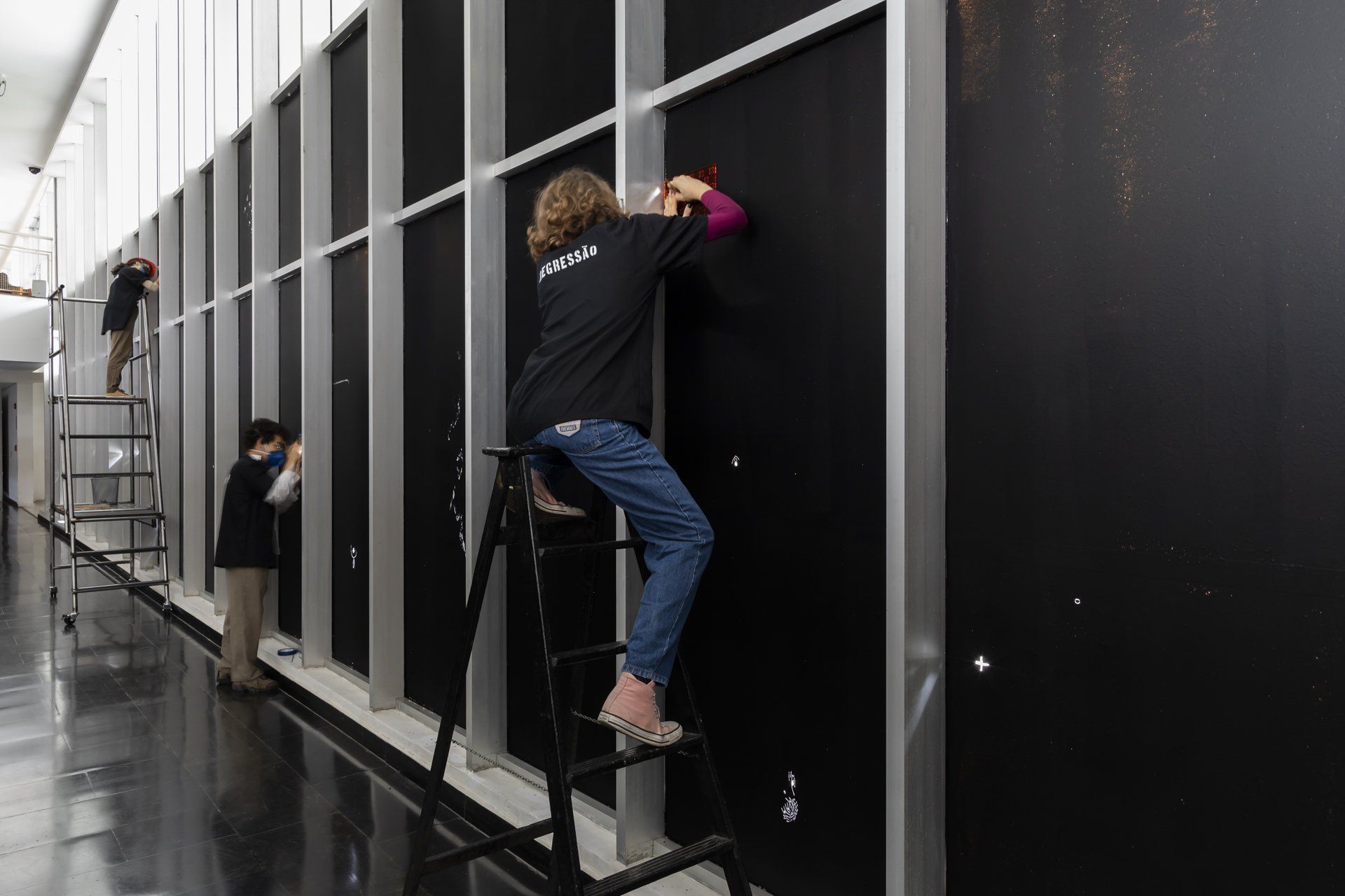 Uma mulher está em uma escada em frente a uma parede.