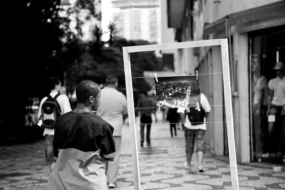 Uma foto em preto e branco de um homem segurando um porta-retratos.