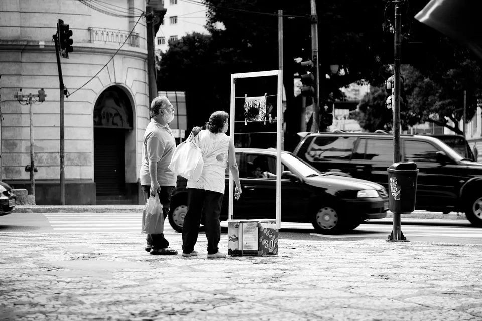 Uma foto em preto e branco de duas pessoas paradas em uma esquina.