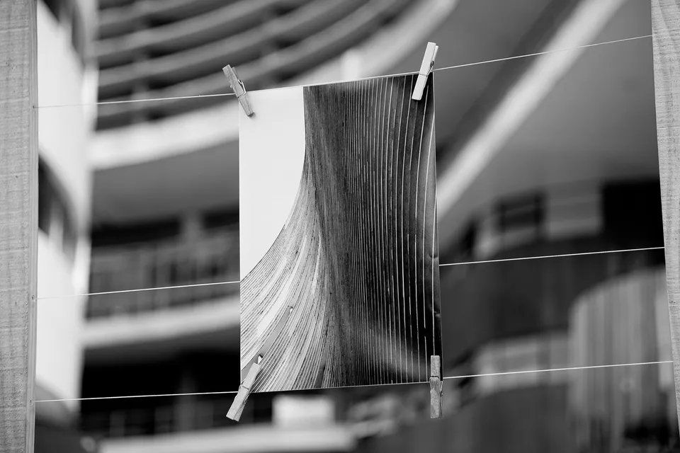 Uma foto em preto e branco do cabelo de uma mulher pendurado em um varal
