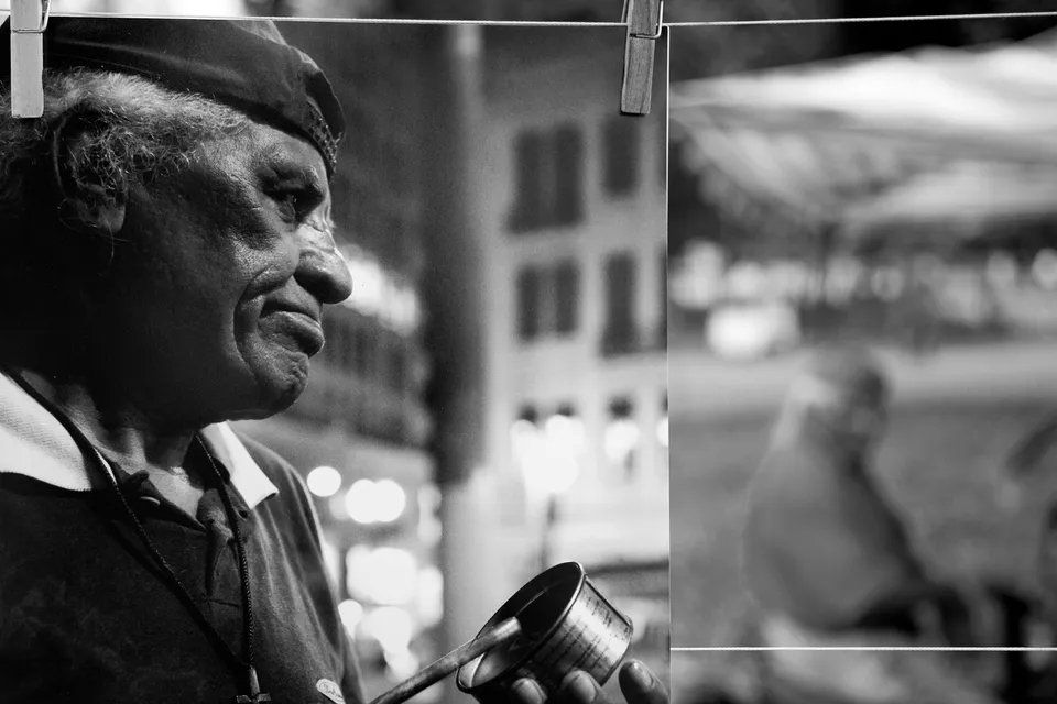 Uma foto em preto e branco de um homem segurando uma lata.