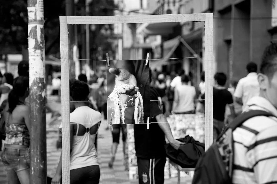 Uma foto em preto e branco de pessoas andando por uma rua.