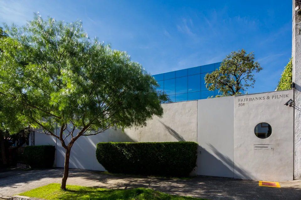 Um grande edifício com uma árvore na frente.