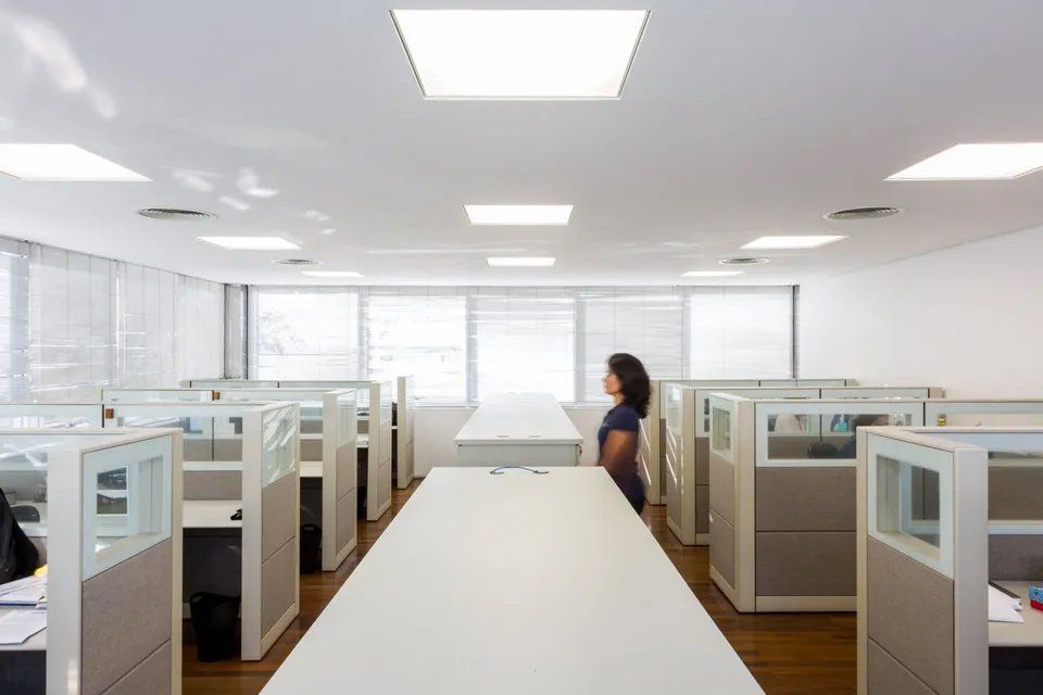 Uma mulher está em um cubículo de um escritório.