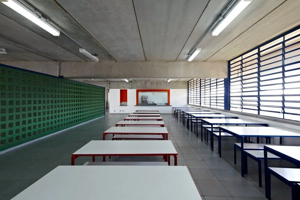 Uma grande sala com mesas e bancos