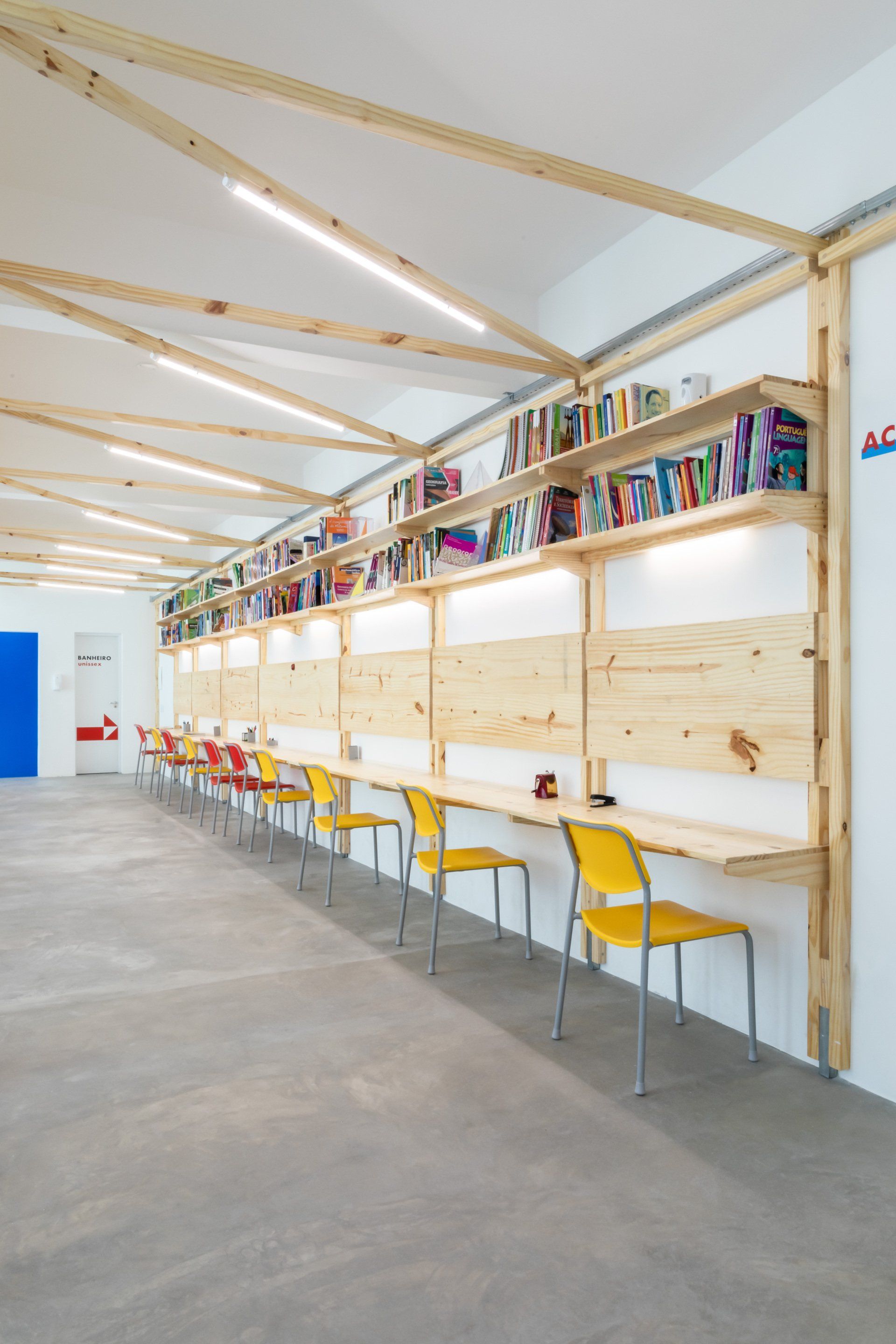 Um longo corredor com uma fileira de mesas e cadeiras.