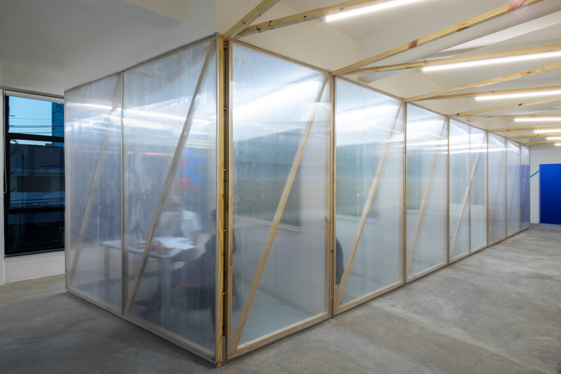 Uma sala com paredes de plástico transparente e vigas de madeira.