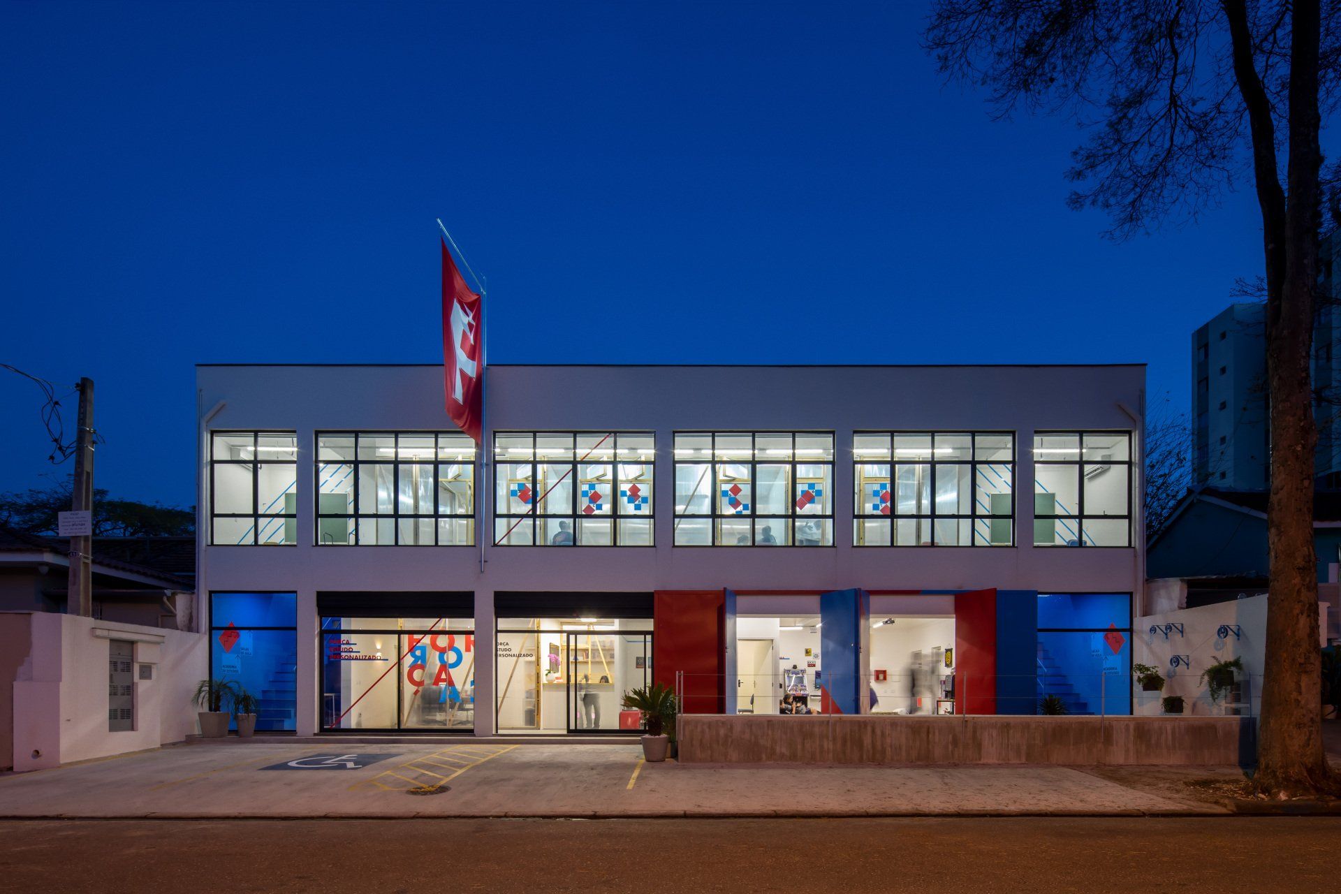 Um grande edifício com uma bandeira no topo à noite.