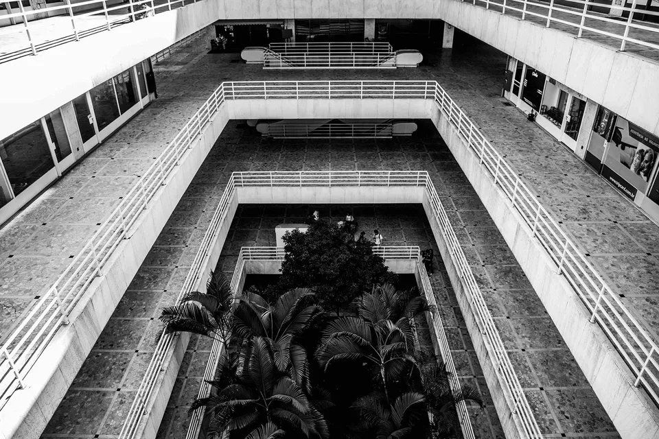 Uma foto em preto e branco de um grande edifício com uma estátua no meio.