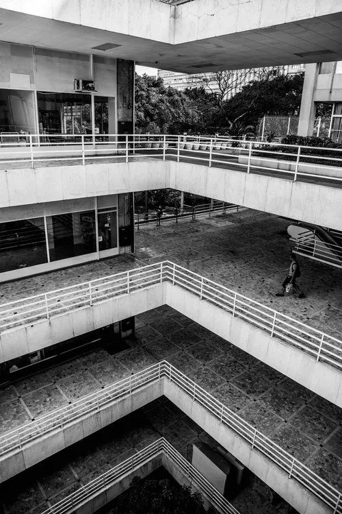 Uma foto em preto e branco de um prédio com muitas escadas.