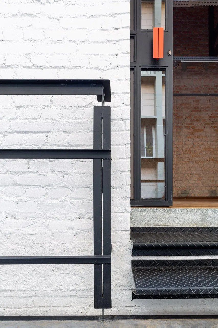 Um prédio de tijolos brancos com corrimão preto e escadas