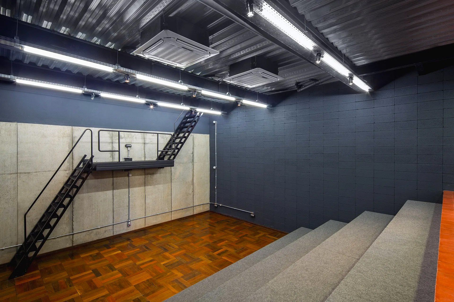 Uma sala vazia com escadas e uma escada de incêndio.