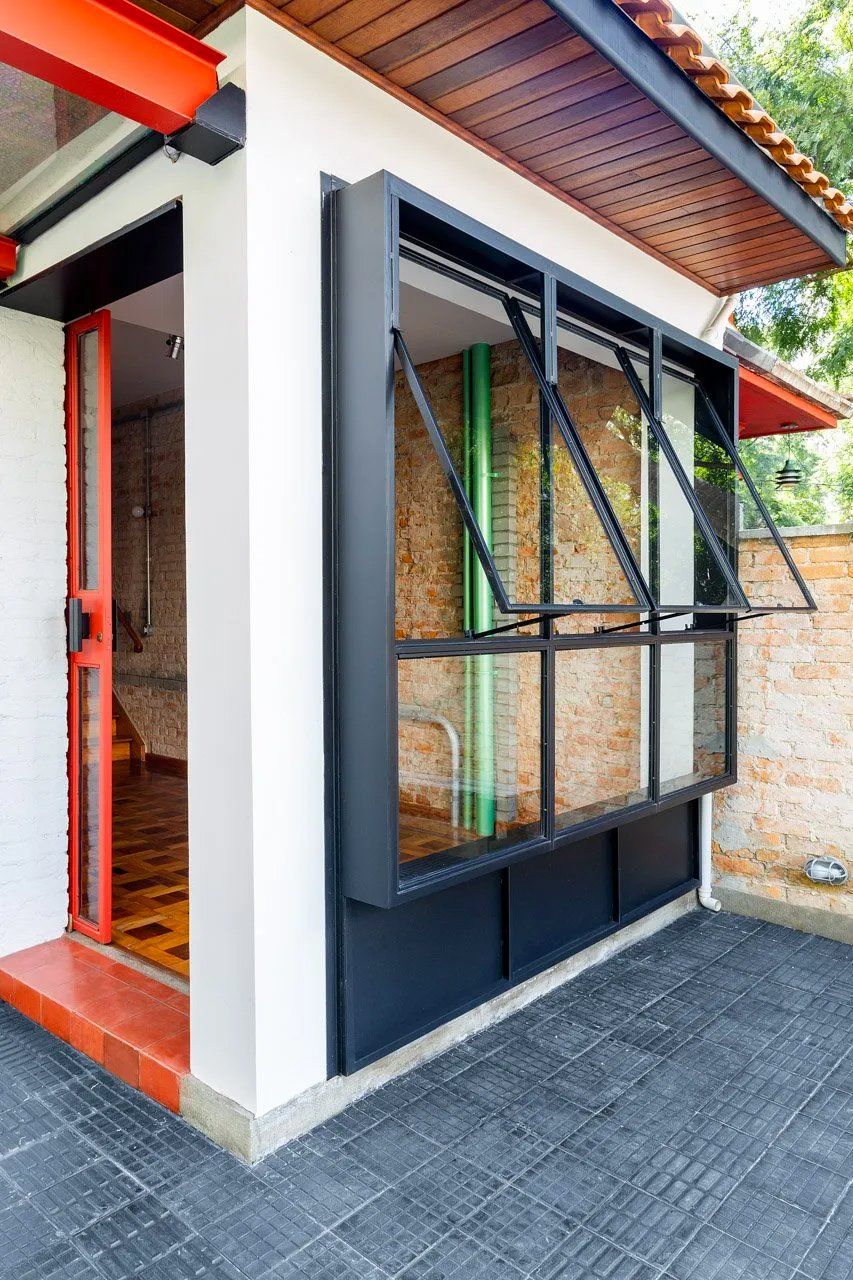 Uma casa com uma grande janela ao lado.