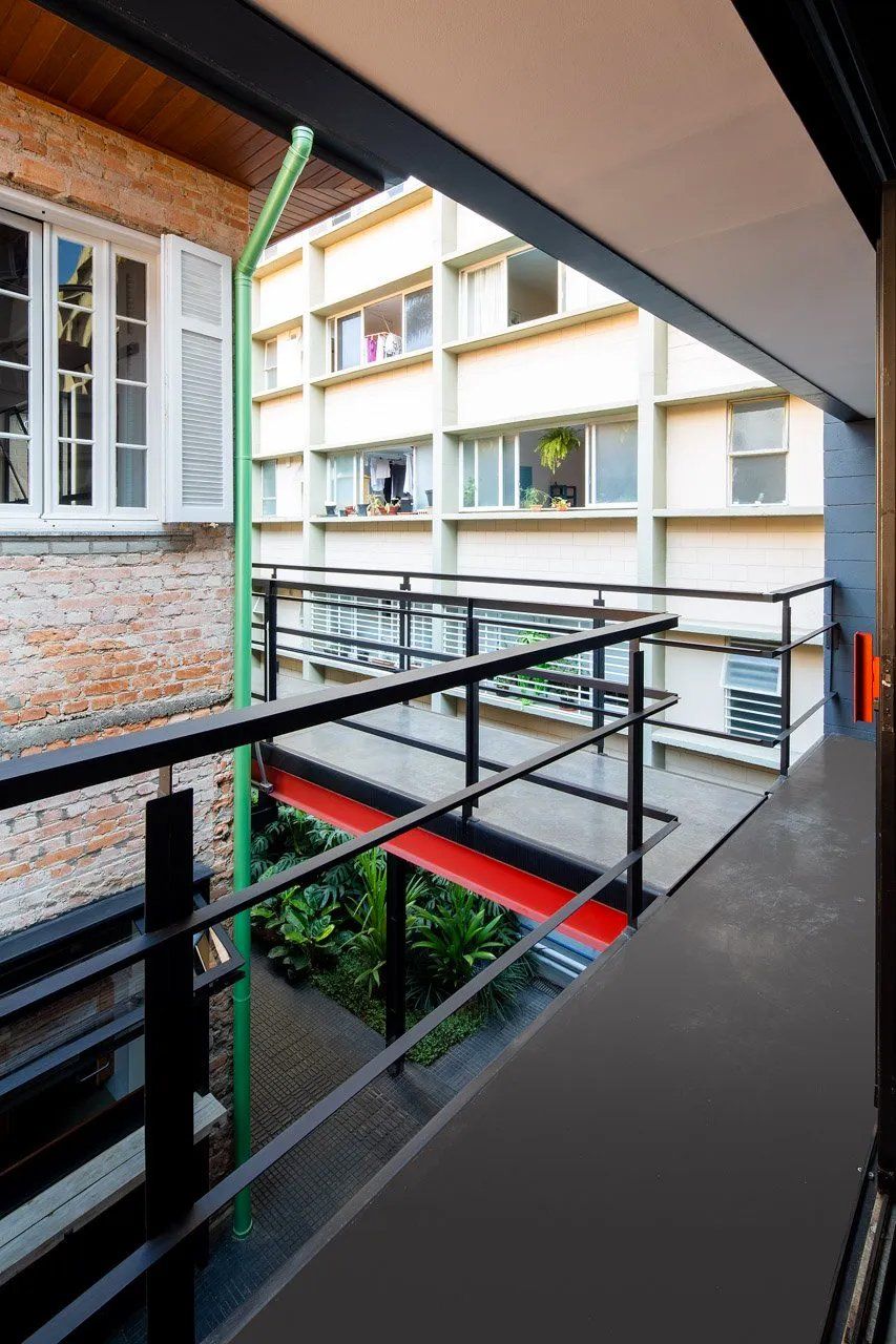 Uma vista de um edifício a partir de uma varanda com um poste verde