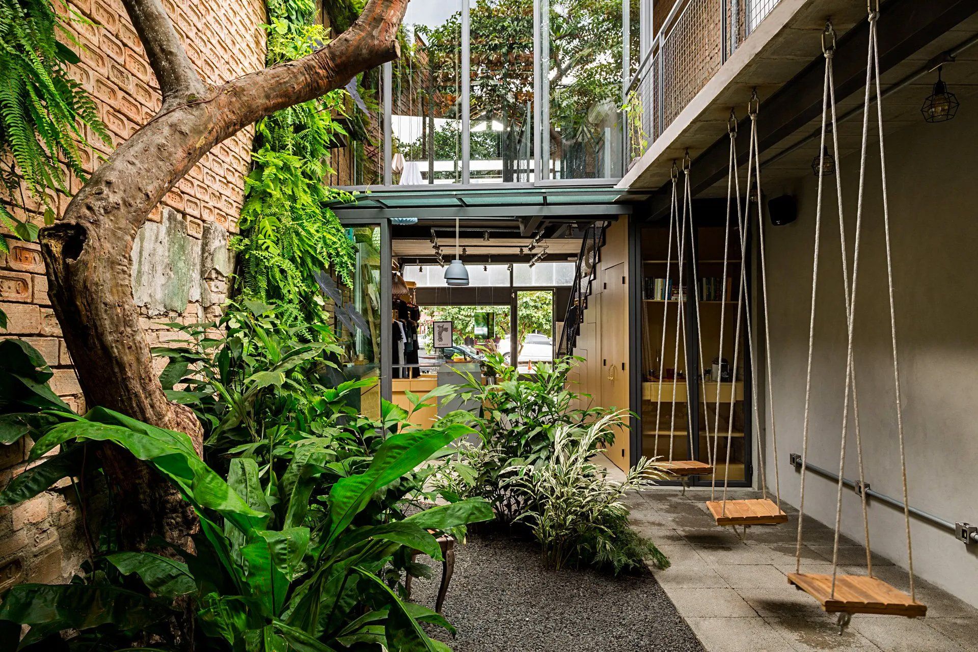 Há balanços pendurados no teto no meio de um pátio.