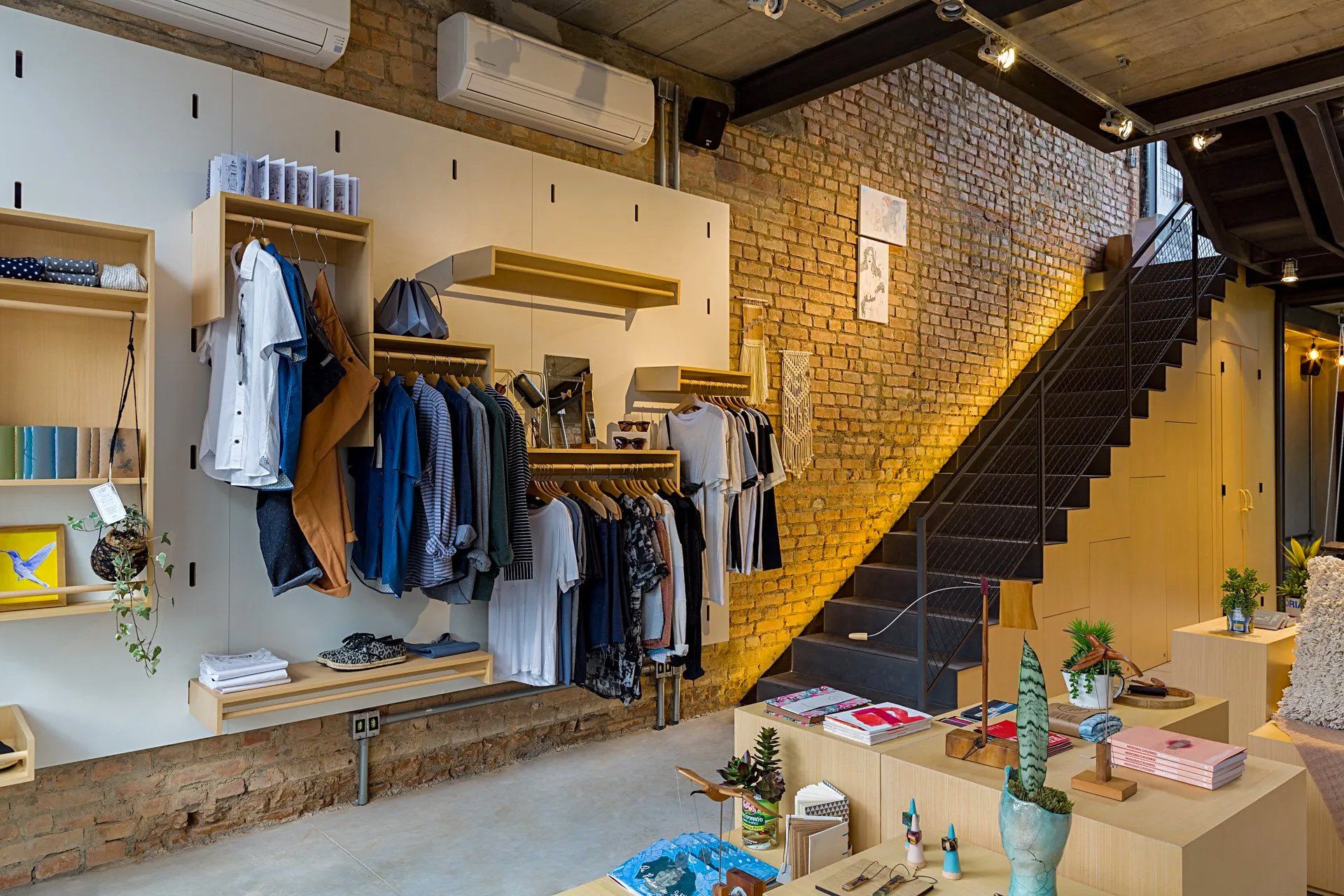 Uma loja de roupas com uma escada que leva ao segundo andar.