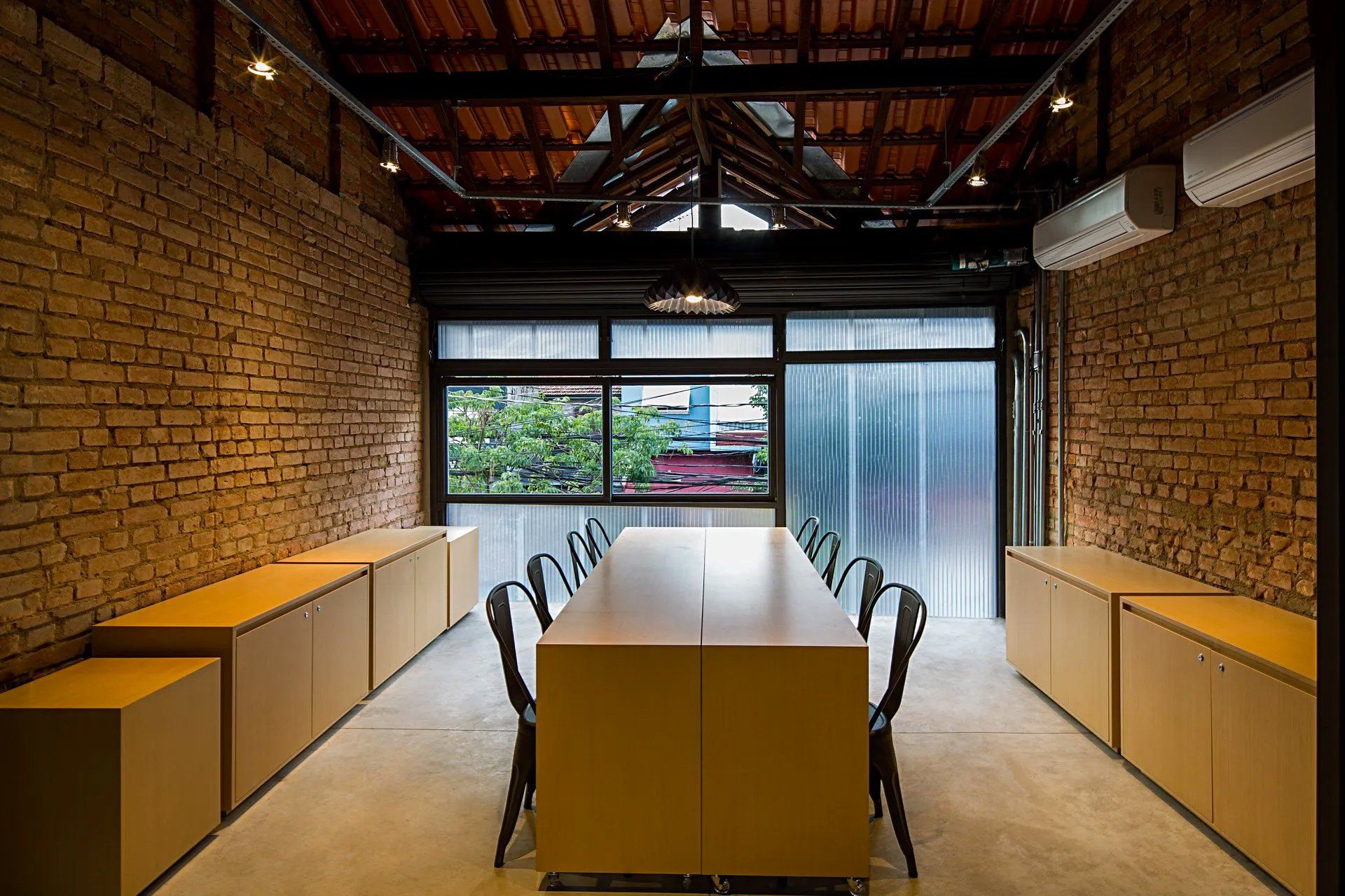 Uma sala com mesa e cadeiras e uma parede de tijolos.