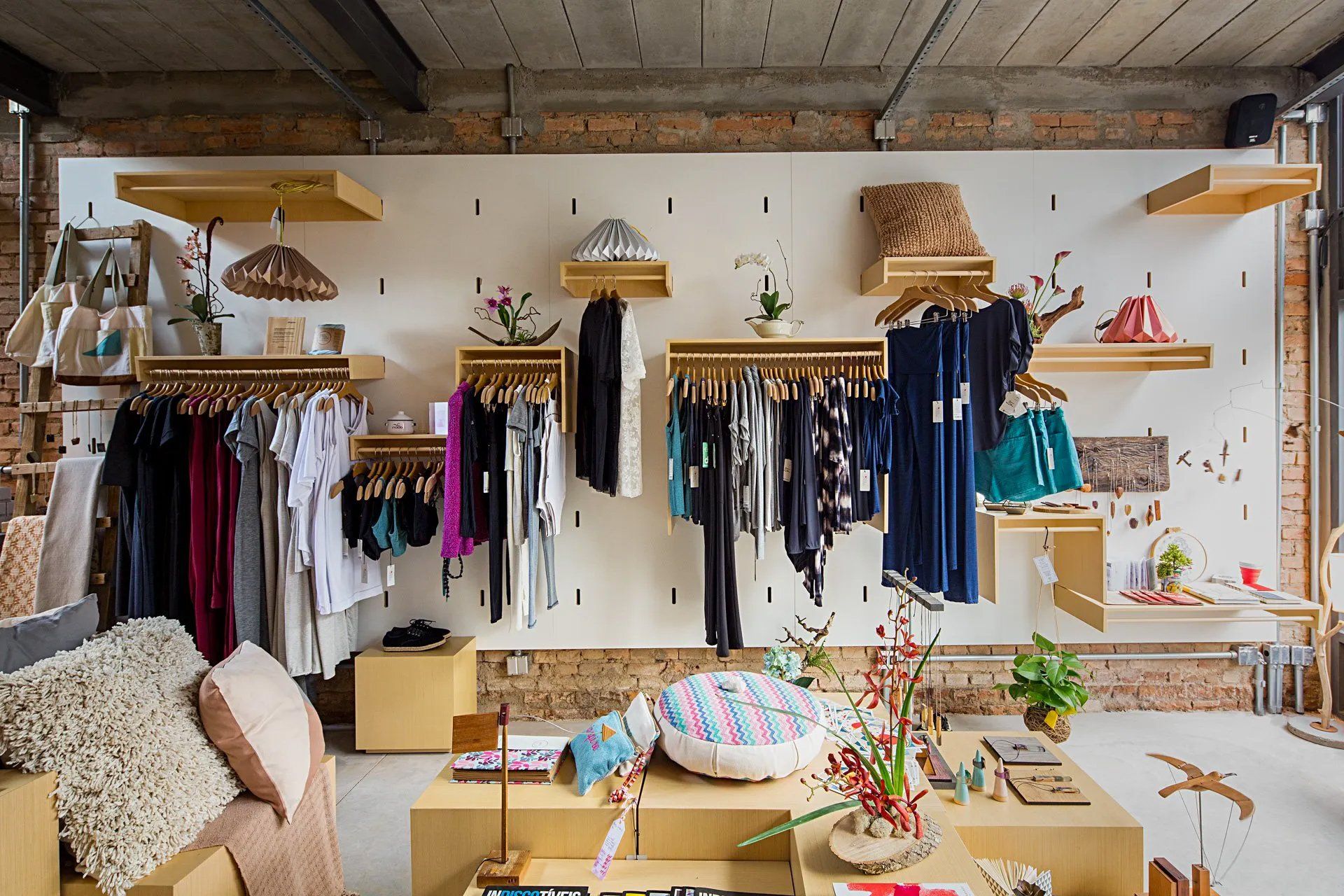 Uma loja de roupas com muitas roupas penduradas na parede.