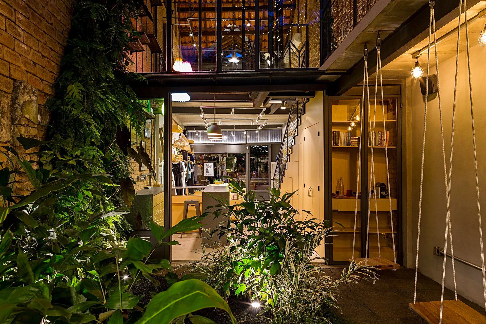 Uma casa com muitas plantas e um balanço na frente.