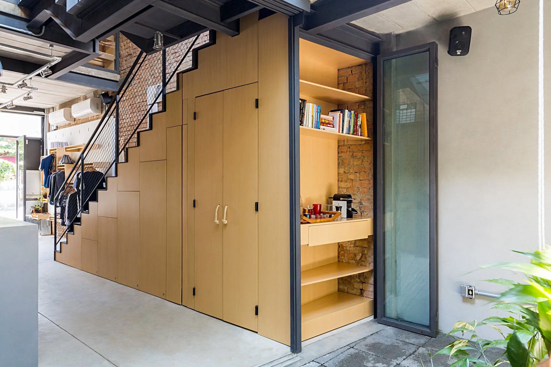 Um quarto com escada e um armário embaixo dela.