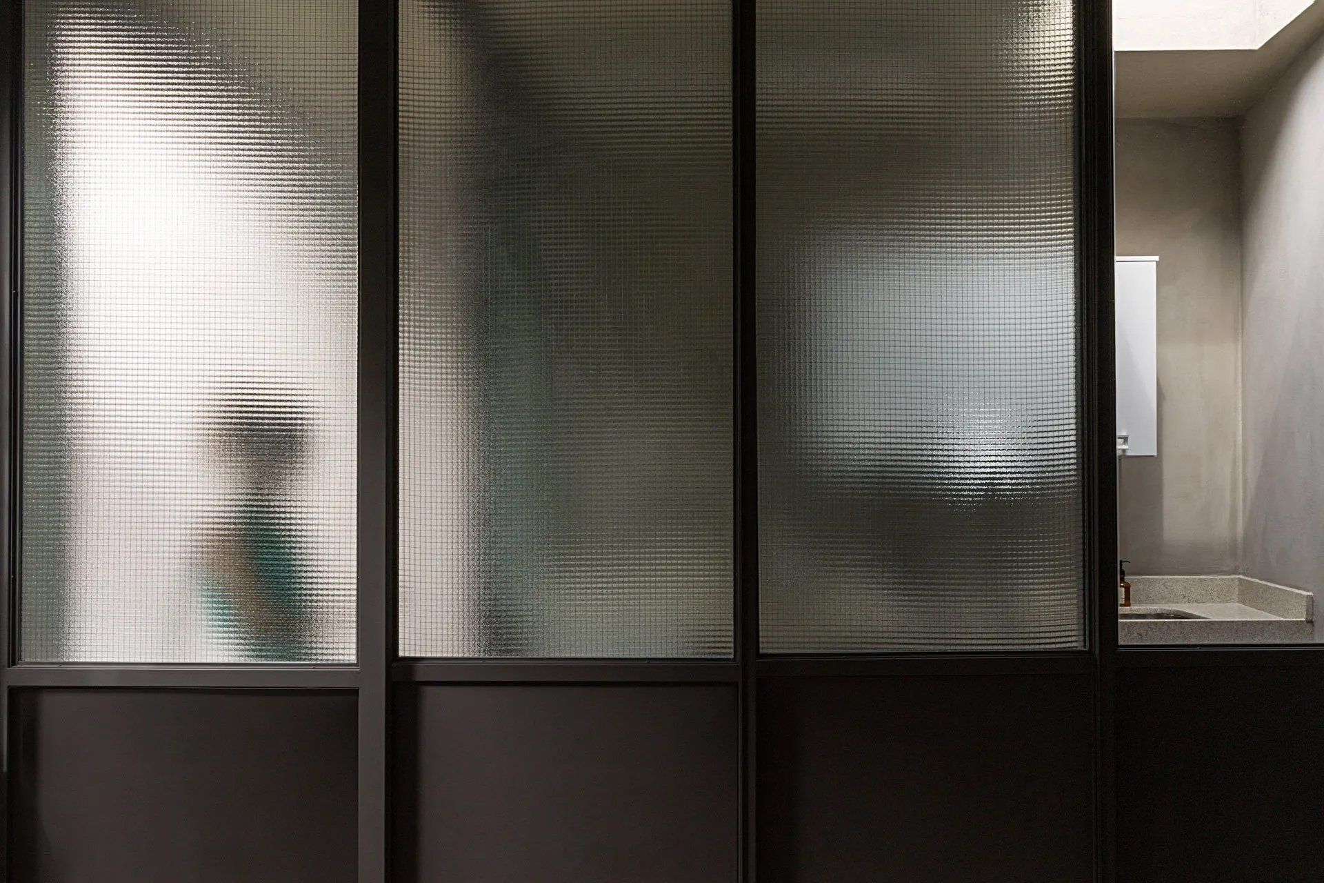 Uma sala com parede de vidro e porta de correr de vidro.