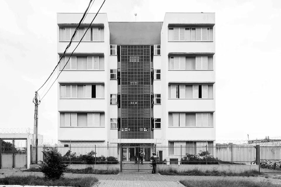 Uma foto em preto e branco de um grande prédio de apartamentos