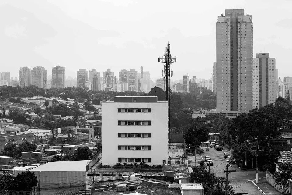 Uma foto em preto e branco de uma cidade com um prédio alto em primeiro plano