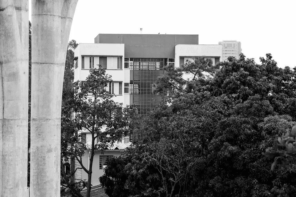 Uma foto em preto e branco de um prédio cercado por árvores.