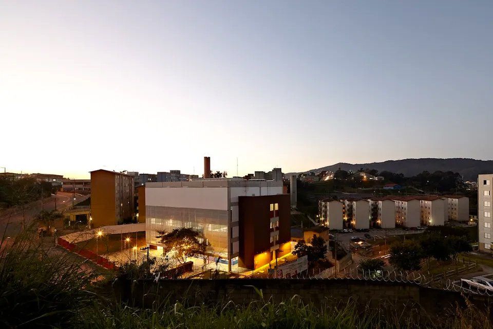 Um grande edifício está situado no topo de uma colina no meio de uma cidade.