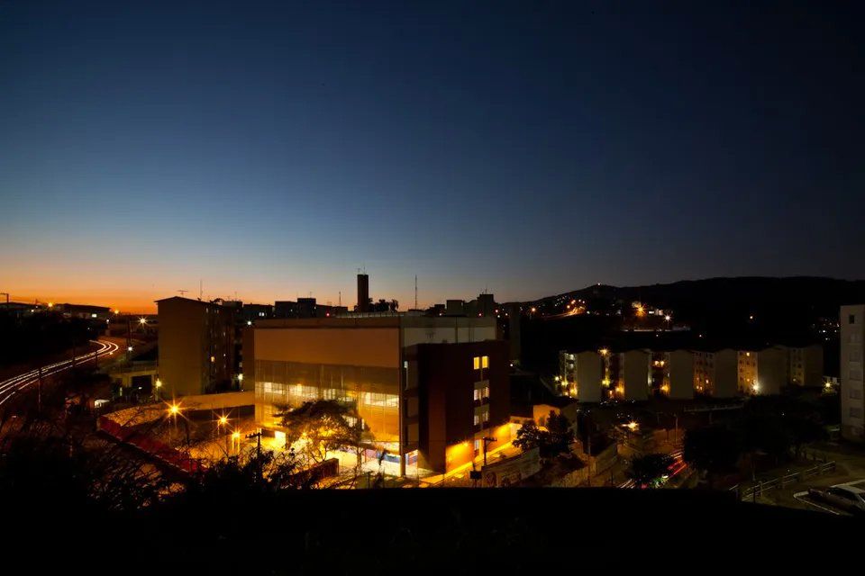 Um grande edifício é iluminado à noite em uma cidade.