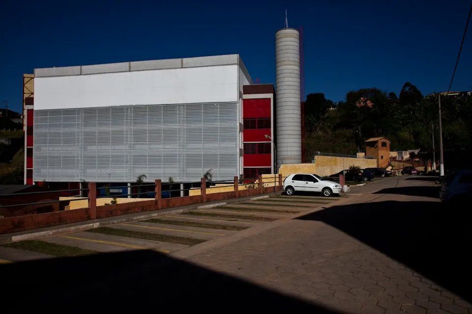 Um carro branco está estacionado em frente a um grande edifício