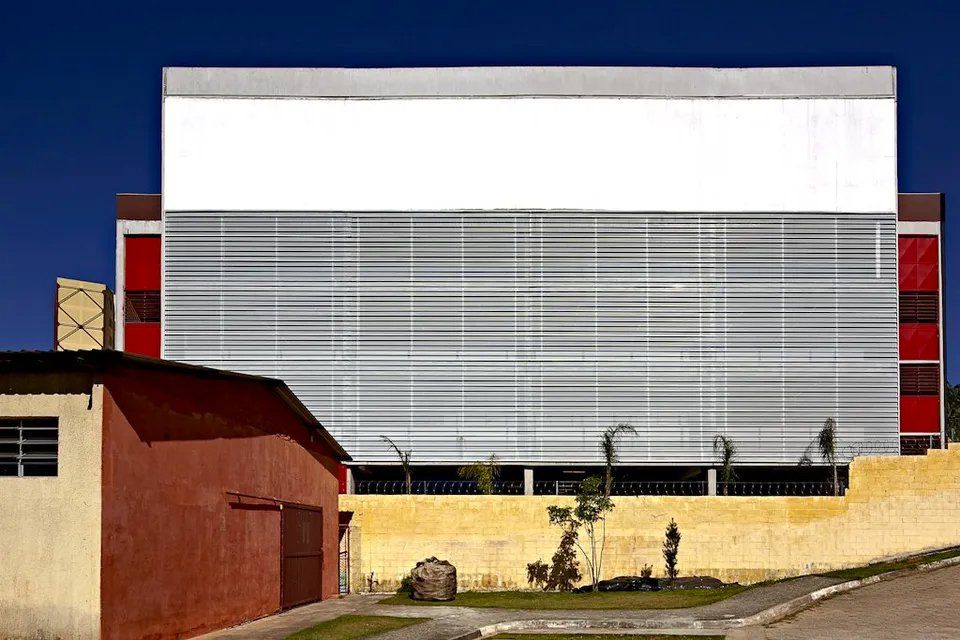 Um grande edifício com uma grande placa branca ao lado.