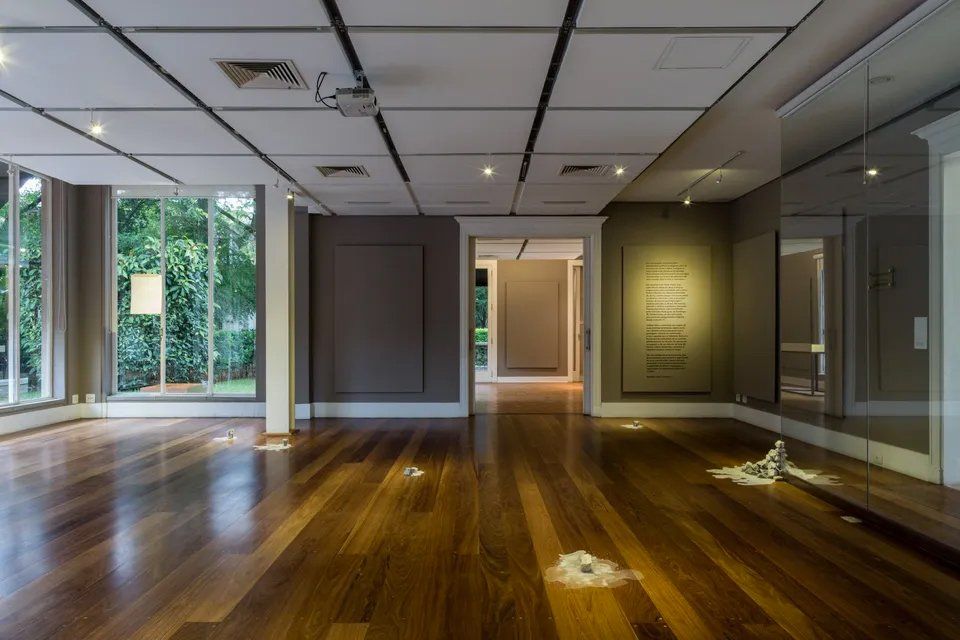 Uma sala vazia com piso de madeira e muitas janelas