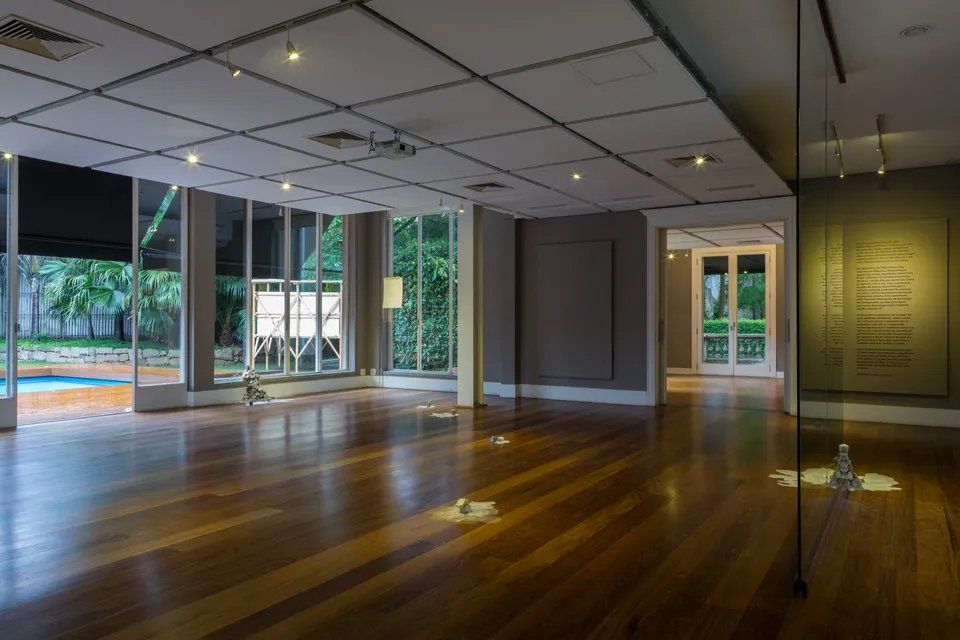 Uma sala vazia com piso de madeira e muitas janelas