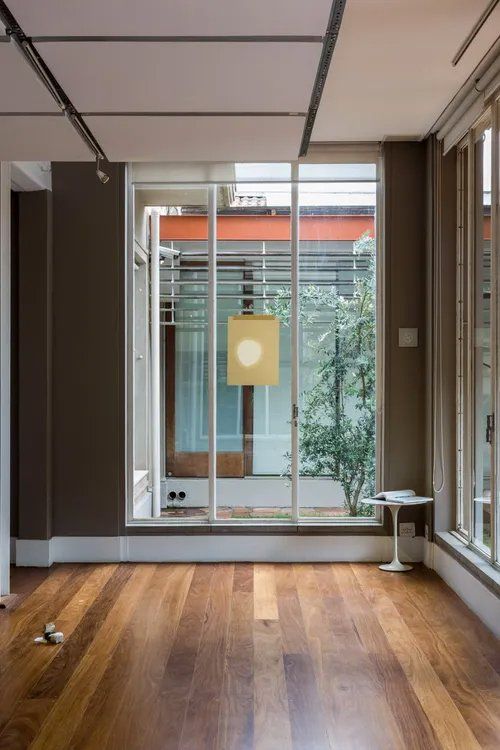 Uma sala vazia com piso de madeira e uma grande janela