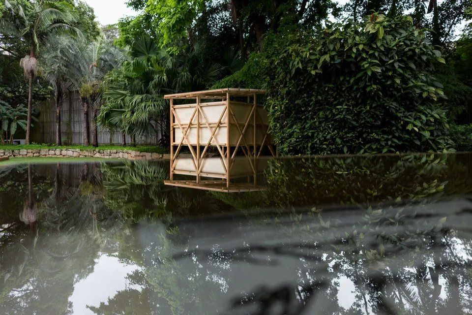 Uma estrutura de madeira está situada no meio de um lago cercado por árvores.